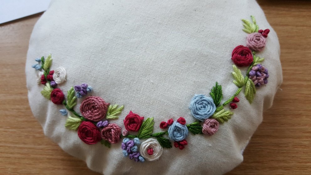 Hér er mynd af útsaumsprufu sem varð að dúkkukodda.