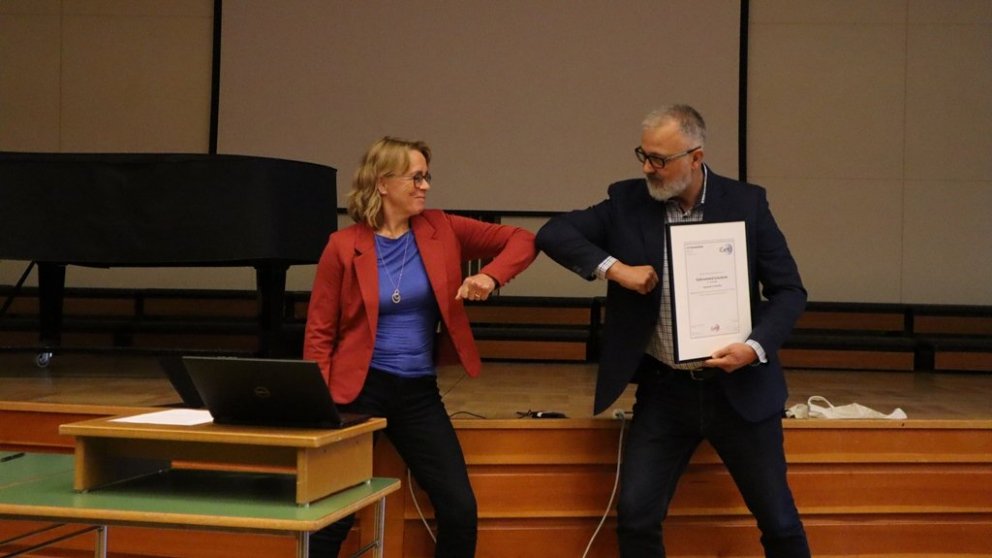 Skólameistari tekur á móti skírteini um jafnlaunavottun FSu frá Sigurði Harðasyni.
