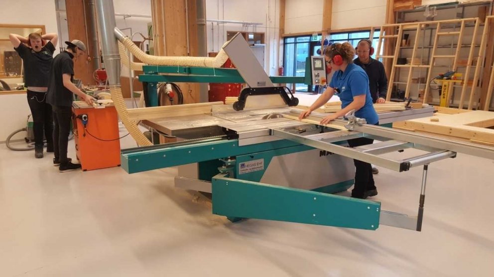 Nemendur í húsasmíði að vinna með plötusög og borðfræsara.