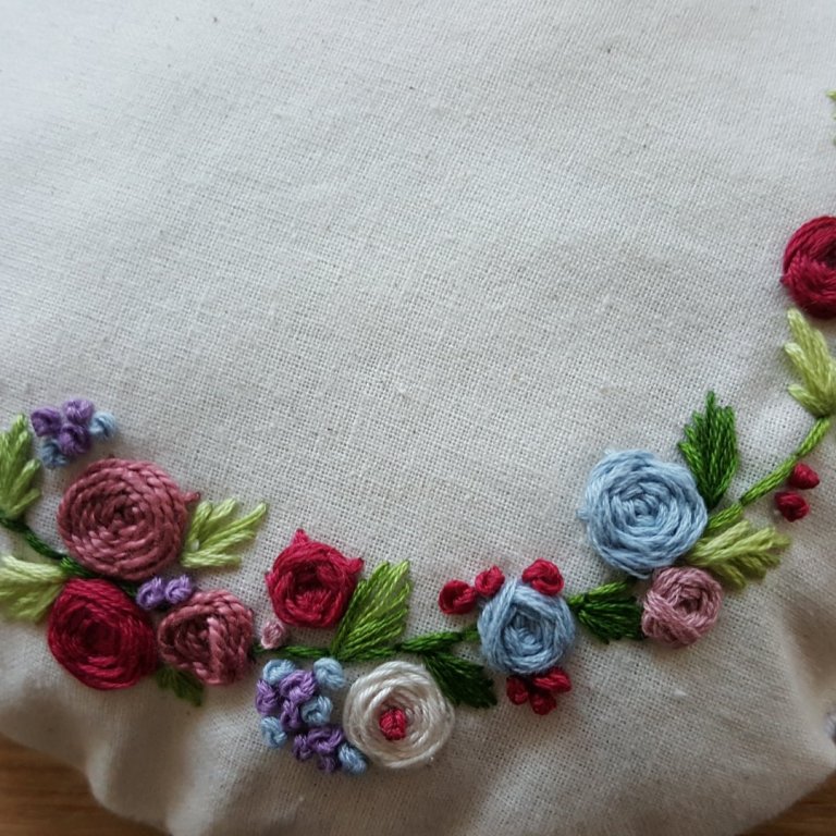 Hér er mynd af útsaumsprufu sem varð að dúkkukodda.