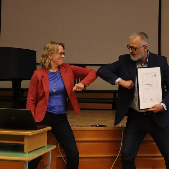 Skólameistari tekur á móti skírteini um jafnlaunavottun FSu frá Sigurði Harðasyni.