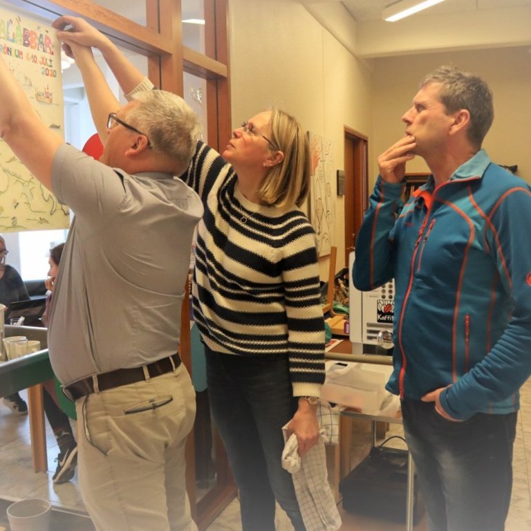 Björgvin, Elín og Sverrir hjálpast að við að hengja upp auglýsingu Abbalabba